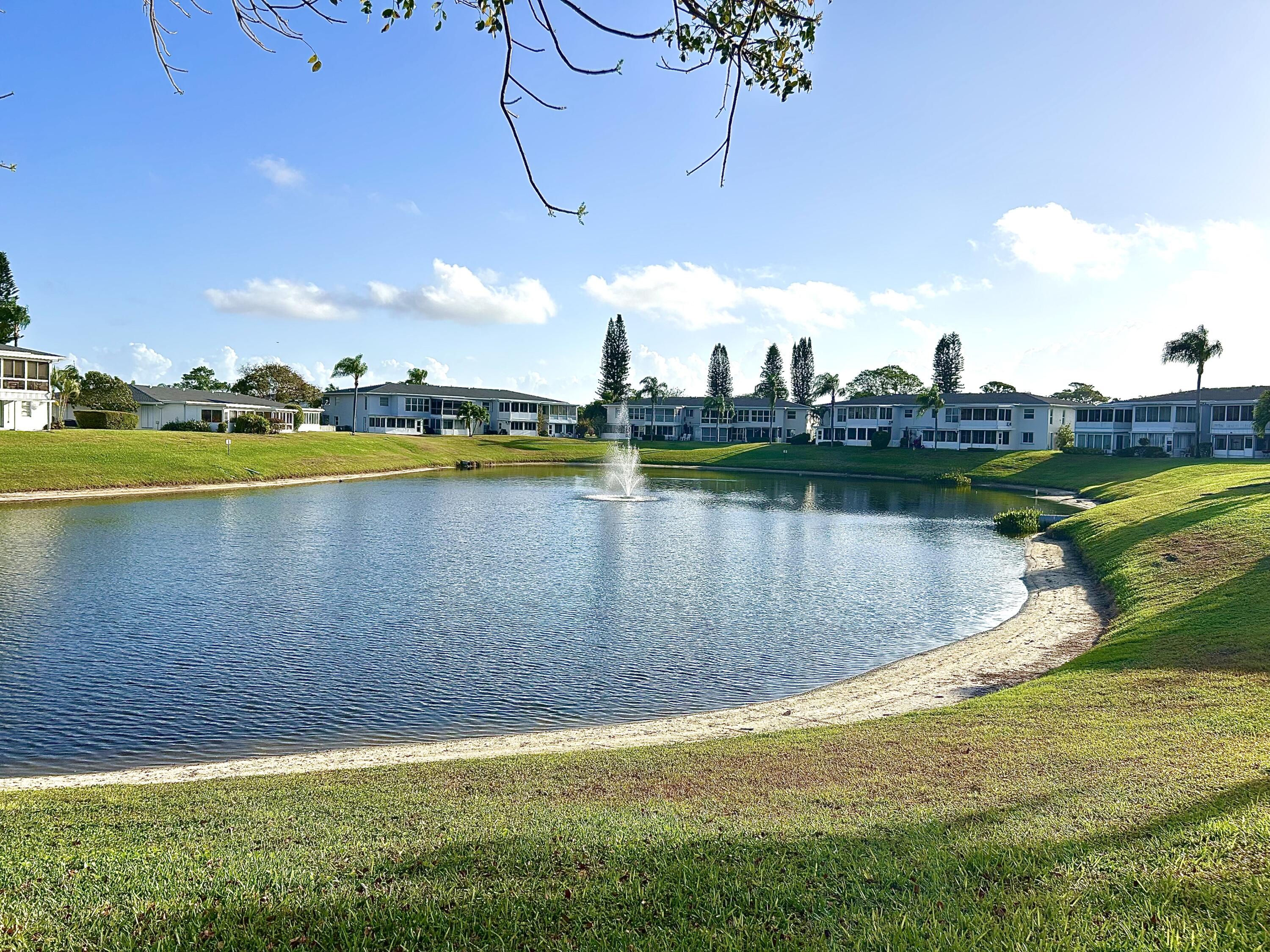 2811 Southwest 15th Street, Unit 202 Delray Beach, FL 33445 - Photo 2 of 21 a view of a lake with houses in the back