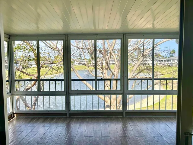a view of wooden floor and a window in a room