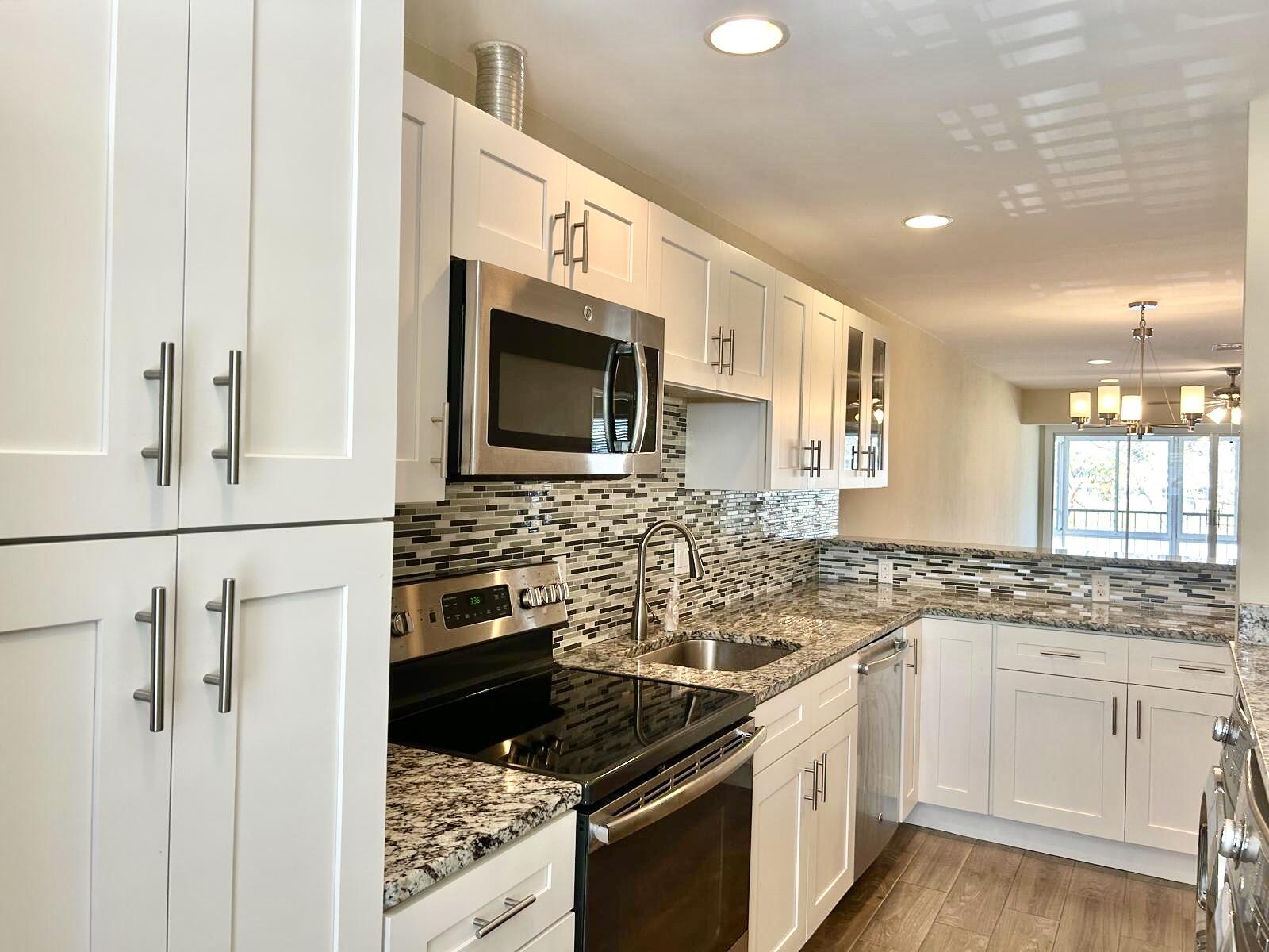 2811 Southwest 15th Street, Unit 202 Delray Beach, FL 33445 - Photo 4 of 21 a kitchen with a sink stove and microwave
