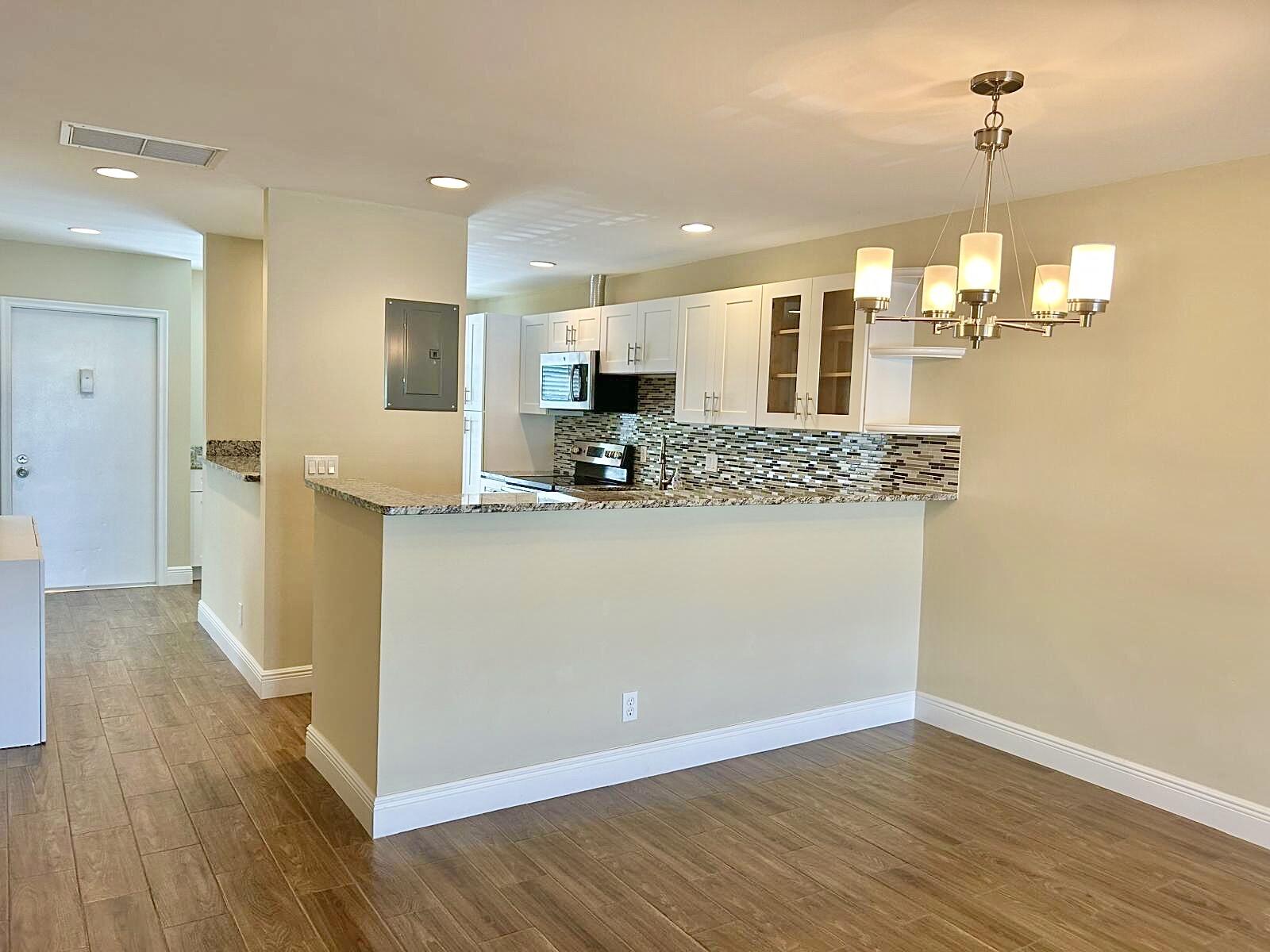 2811 Southwest 15th Street, Unit 202 Delray Beach, FL 33445 - Photo 6 of 21 a view of a kitchen cabinets and chandelier