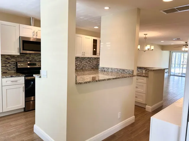 a kitchen with kitchen island granite countertop a refrigerator and a stove