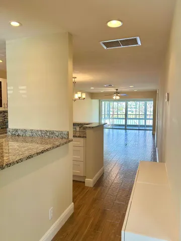 a view of a living room with wooden floor and a floor to ceiling window