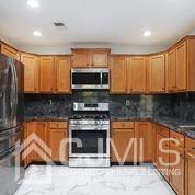 19 Madison Drive Helmetta, NJ 08828 - Photo 15 of 45 a kitchen with stainless steel appliances granite countertop a stove top oven microwave and cabinets