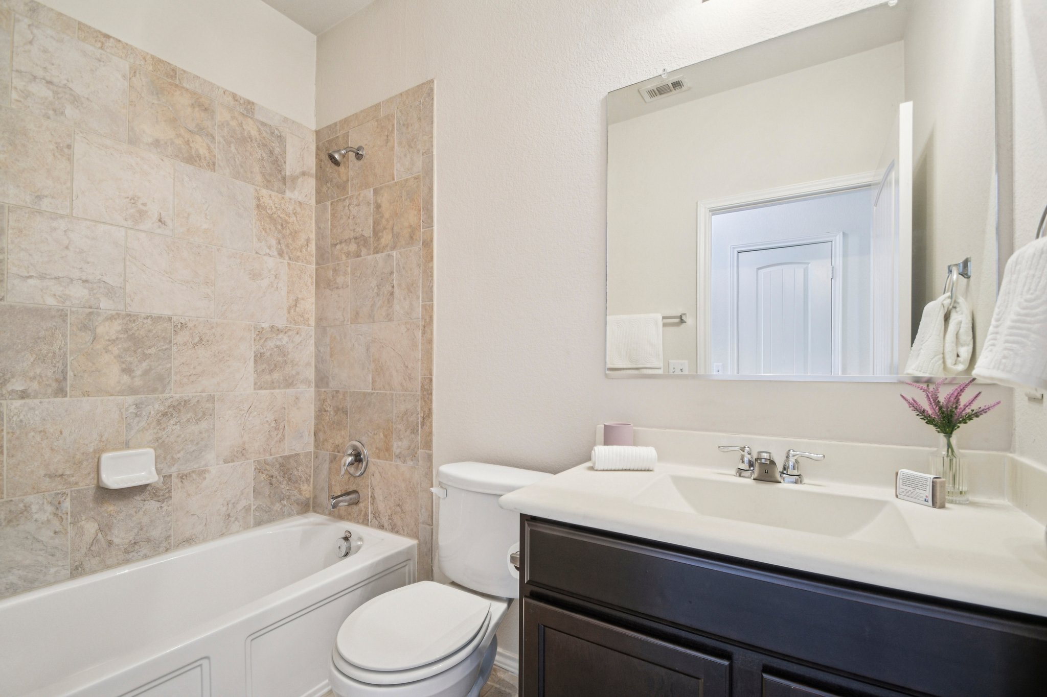 10221 Pinnacle Crest Loop Austin, TX 78747 - Photo 13 of 19 a bathroom with a sink a toilet a mirror a bathtub and shower
