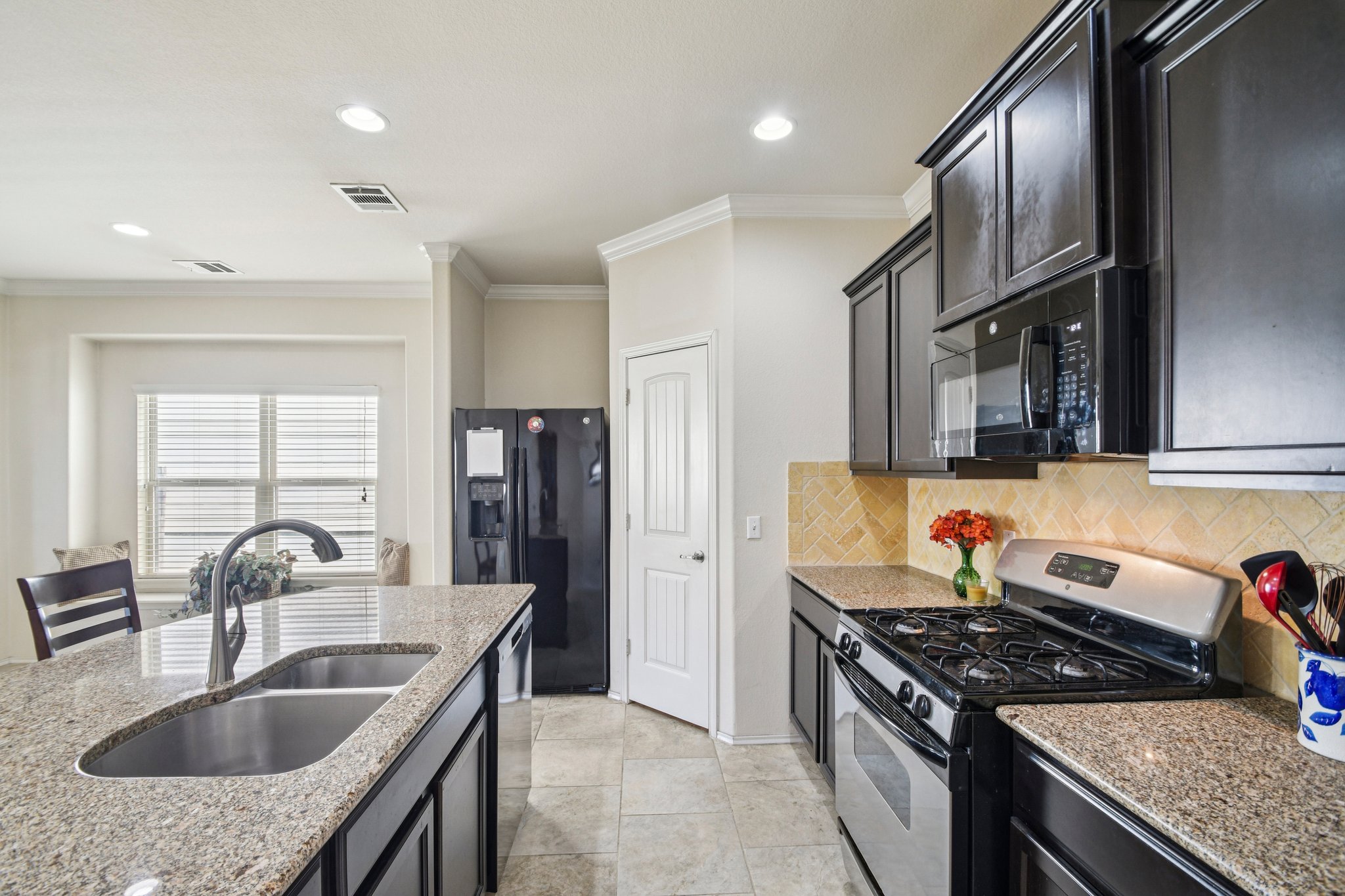 10221 Pinnacle Crest Loop Austin, TX 78747 - Photo 7 of 19 a kitchen with granite countertop a sink stainless steel appliances and cabinets