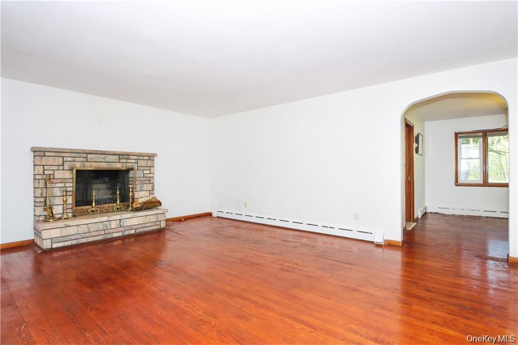 26 Montrose Point Road Montrose, NY 10548 - Photo 5 of 20 an empty room with wooden floor fireplace and windows