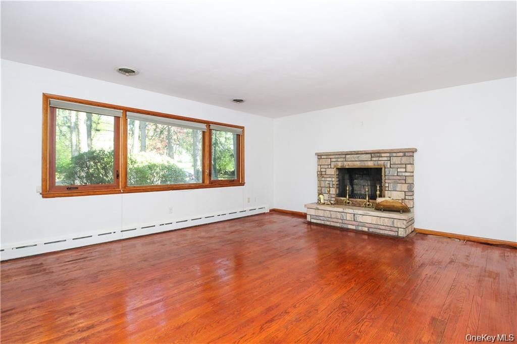 26 Montrose Point Road Montrose, NY 10548 - Photo 7 of 20 an empty room with wooden floor and fireplace
