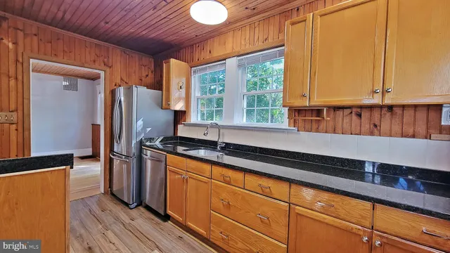 a kitchen with stainless steel appliances granite countertop a refrigerator and a sink