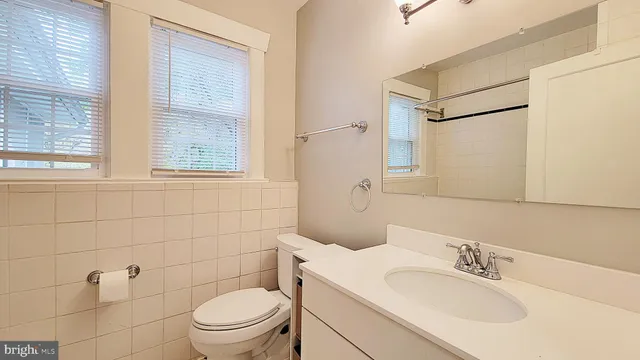 a bathroom with a sink a toilet and a mirror