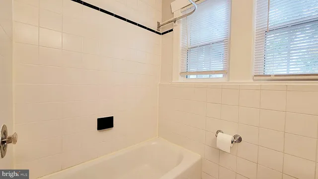 a bathroom with a white bath tub and a window