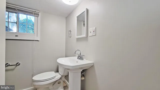 a bathroom with a sink a toilet and a mirror