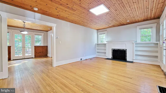a view of empty room with wooden floor and fireplace