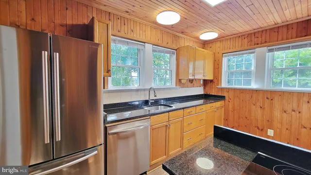 a kitchen with granite countertop a refrigerator and a sink