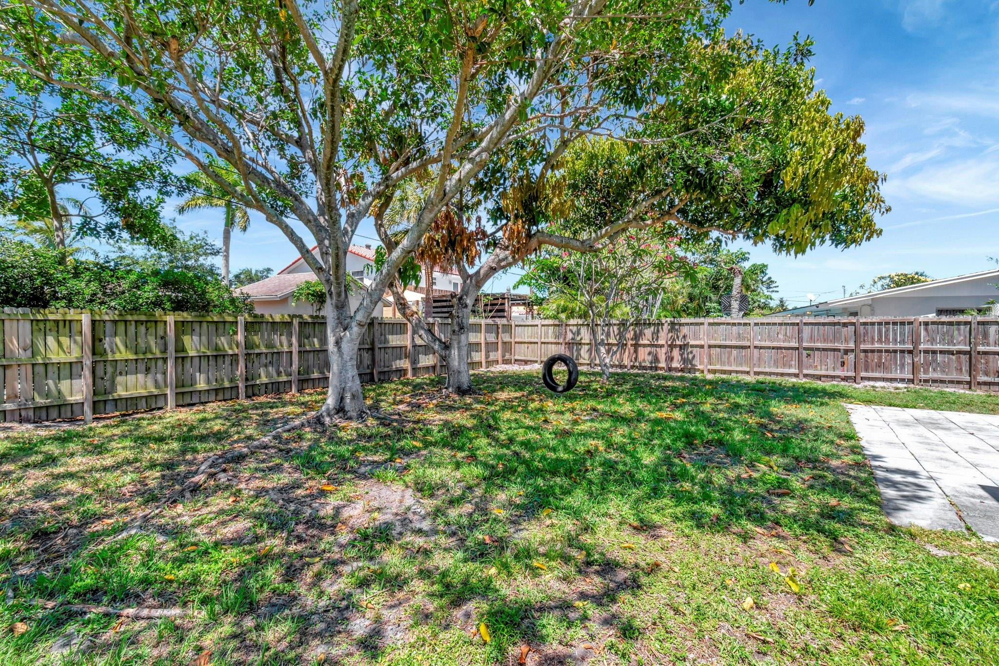 1617 Northwest 4th Street Boca Raton, FL 33486 - Photo 43 of 45 a view of backyard with wooden fence and a large tree