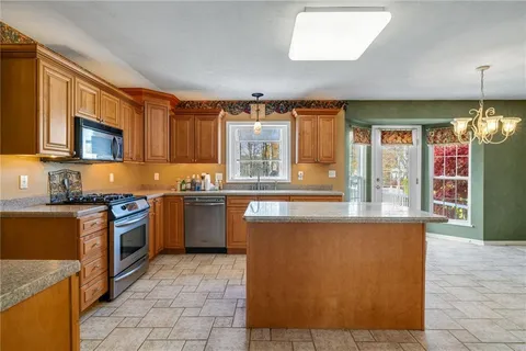 a kitchen with stainless steel appliances granite countertop a stove a sink and a microwave