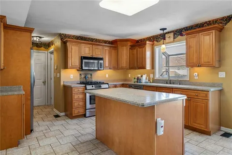 a kitchen with granite countertop a sink stove and refrigerator