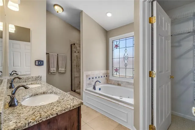 a bathroom with a granite countertop tub sink and mirror