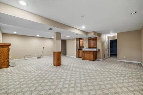 a kitchen with stainless steel appliances kitchen island granite countertop a refrigerator and a sink