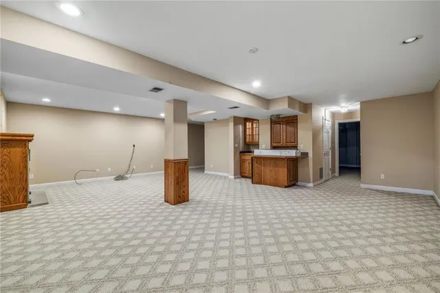 a kitchen with stainless steel appliances kitchen island granite countertop a refrigerator and a sink