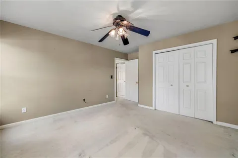 a view of an empty room and chandelier fan