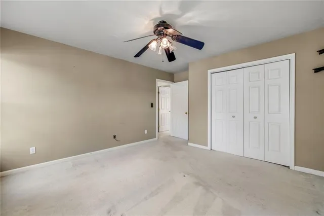 a view of an empty room and chandelier fan