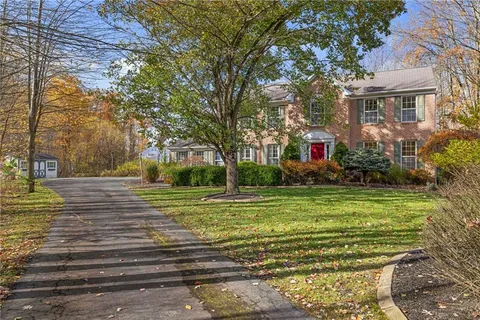 a view of a house in a big yard with large trees