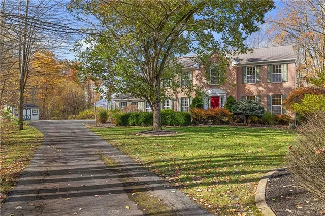 a view of a house in a big yard with large trees