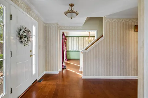 a view of hallway with stairs and wooden floor