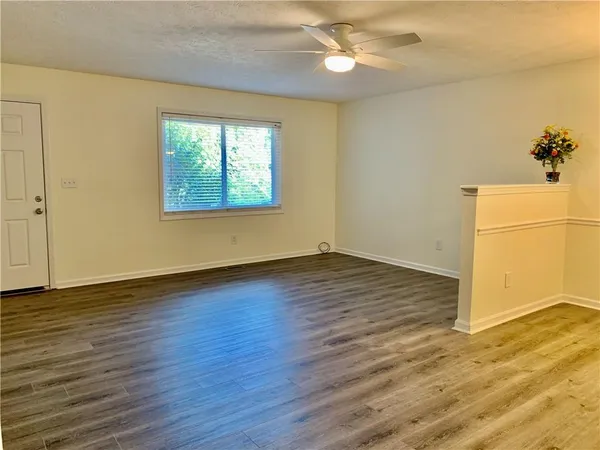 an empty room with wooden floor and windows