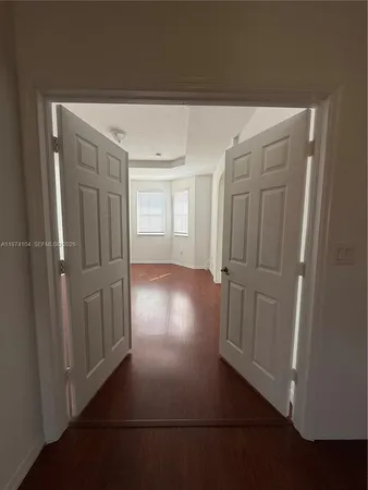 an empty room with wooden floor and windows in it