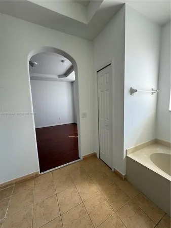 a large white room with mirror and shower