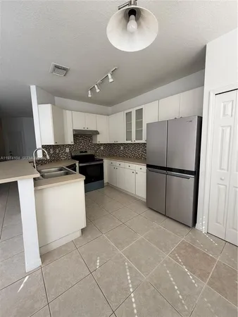 a kitchen with stainless steel appliances granite countertop a refrigerator a stove a sink and a microwave