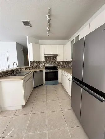 a kitchen with stainless steel appliances granite countertop a refrigerator and a stove