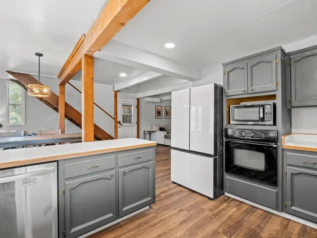 an aerial view of residential houses with outdoor space and trees