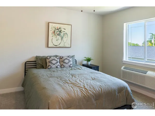 a bedroom with a bed and painting on the wall