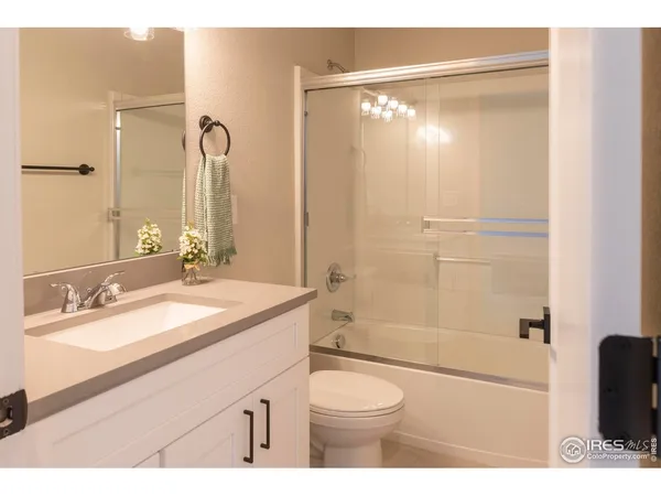 a bathroom with a granite countertop sink toilet a mirror a shower and bathtub