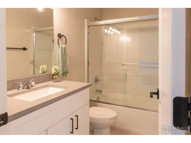 a bathroom with a granite countertop sink toilet a mirror a shower and bathtub