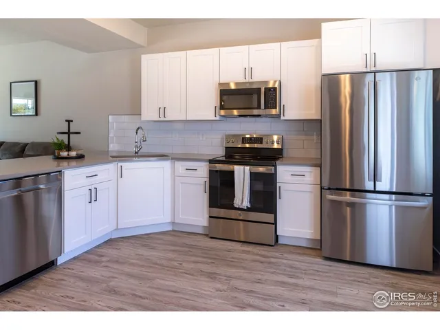 a kitchen with stainless steel appliances a refrigerator sink and microwave