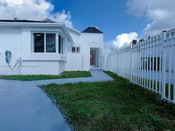 a view of a house with wooden fence