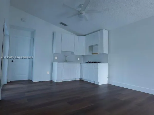 an empty room with wooden floor & windows