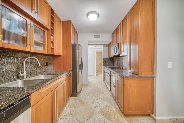 a kitchen with stainless steel appliances granite countertop a sink stove and refrigerator