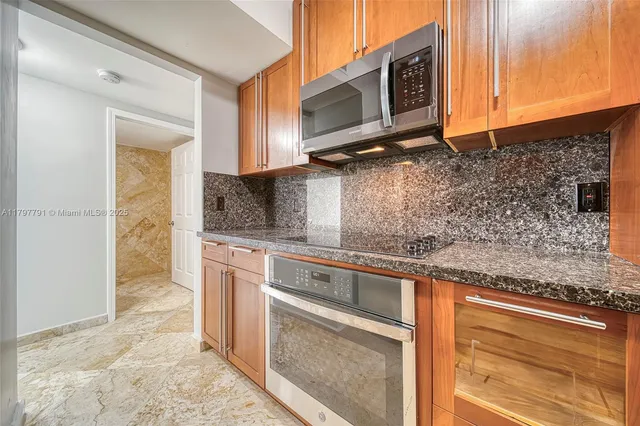 a kitchen with stainless steel appliances granite countertop a sink stove and microwave