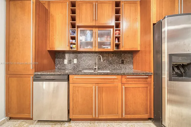 a kitchen with stainless steel appliances granite countertop a refrigerator and a sink