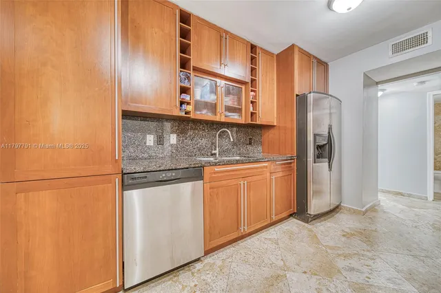 a kitchen with stainless steel appliances granite countertop a refrigerator and a stove