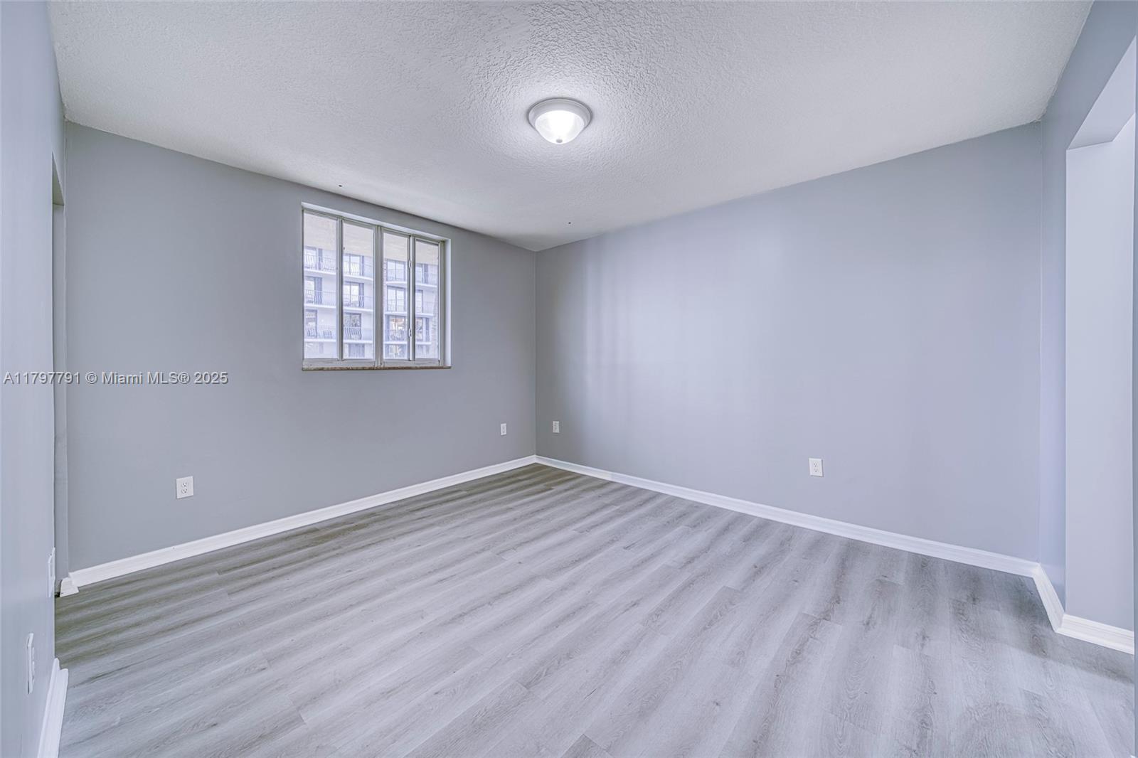 8888 Collins Avenue, Unit 201 Surfside, FL 33154 - Photo 17 of 37 wooden floor in an empty room with a window