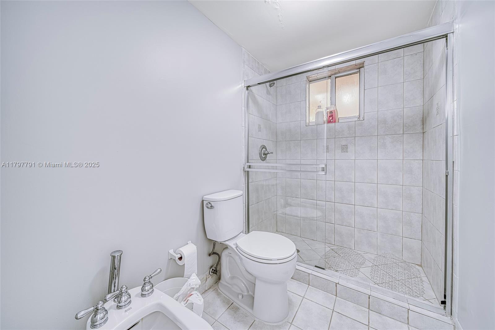 8888 Collins Avenue, Unit 201 Surfside, FL 33154 - Photo 22 of 37 a white toilet sitting next to a bathroom sink