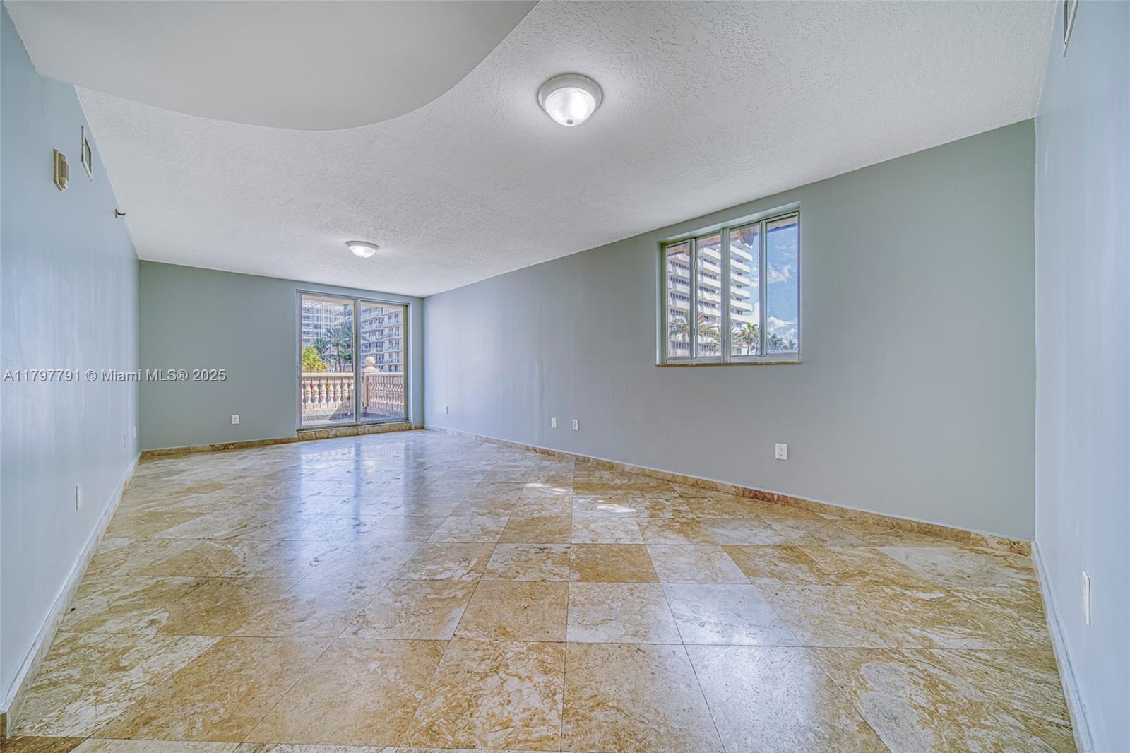 8888 Collins Avenue, Unit 201 Surfside, FL 33154 - Photo 24 of 37 an empty room with windows and entrance