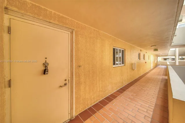 a view of a hallway with wooden floor and a bathroom