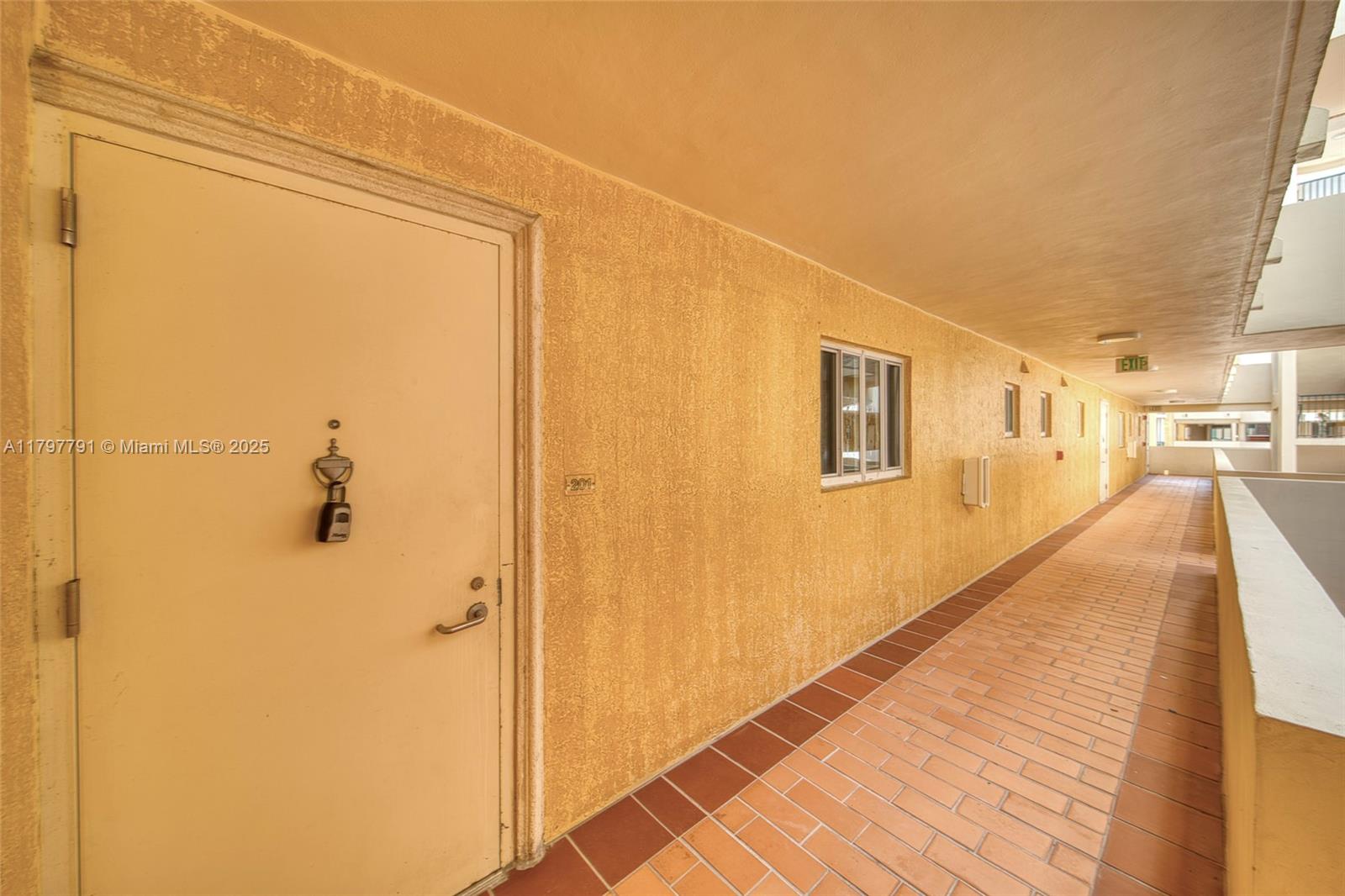 8888 Collins Avenue, Unit 201 Surfside, FL 33154 - Photo 3 of 37 a view of a hallway with wooden floor and a bathroom