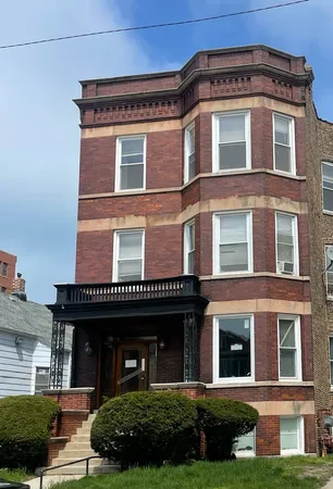a front view of a residential apartment building with a yard